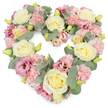 A richly detailed heart-shaped floral tribute fills the frame, set against a clean white background that highlights every pastel bloom and curve. The heart is densely composed, its outline perfectly formed by layers of flowers so that no underlying structure is visible, only a soft, continuous surface of petals and foliage. At regular intervals, large cream and soft yellow roses rise slightly above the other flowers, their velvety, spiralled centres suggesting tenderness and deep affection. Nestled around them, clusters of light pink carnations contribute a frothy, ruffled texture, with each little petal catching the light in a slightly different way. Interspersed among these are deeper magenta and mauve-pink lisianthus blossoms whose more open, flute-like forms lend movement and gentle drama, as if the flowers are mid-sigh. Cool, silvery eucalyptus leaves weave through the arrangement, their smooth, roundish leaves and muted grey-green tones adding calm contrast and helping define the heart's clean edges. Tiny, yellowish-green buds appear here and there, subtle reminders of freshness and continuity. The overall effect is of a lush, luxurious wreath that radiates peace, comfort, and enduring love, very much in keeping with the kind of sympathy flowers often chosen for services and memorials around Farnborough's churches and crematorium. Suitable for honouring a cherished partner, family member, or close friend, this floral heart feels like a gentle embrace in flower form, offering solace to those who gather to remember and say their final goodbyes.
