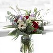 This sophisticated bouquet captures the gentle contrasts and lush vitality of a Farnborough spring. Central to its design are deep merlot roses-their rich hue a bold symbol of affection-balanced beautifully by snowy white gerberas whose mocha centers and immaculate petals evoke clarity and calm. Entering the ensemble, you'll find translucent lavender lisianthus, some artfully closed in bud, each adding a flourish of softness and a whisper of renewal. Fluffy white filler blossoms are interspersed, lending textural interest and drawing the gaze outward, much like wildflowers carpeting a green near Salisbury Road. Cool, aromatic arcs of eucalyptus leaves introduce a silvery shimmer and a breath of tranquil, woodland fragrance. The dark green, sculpted leaves base the bouquet, securing the arrangement in elegant contrast and bringing a sense of order. Nestled in a clear vase, every fresh stem is visible, glistening in water, promising longevity and freshness for deliveries throughout Farnborough. This bouquet, full yet airy, is an invitation to savor life's quieter celebrations-from welcoming a new season to honoring a milestone-each flower chosen to cradle both sentiment and style.